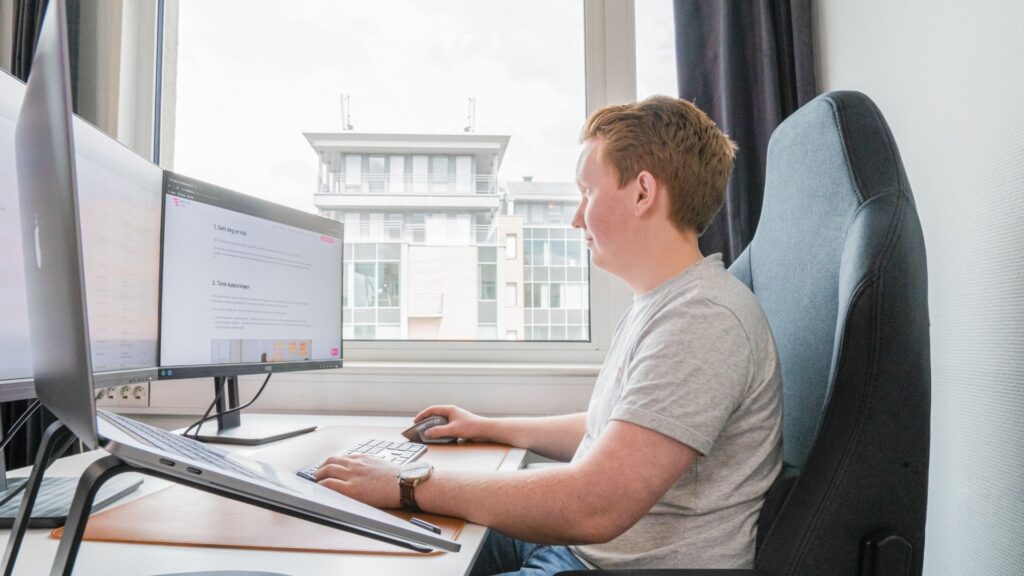 Mann jobber med datamaskiner i et moderne kontor i Oslo.