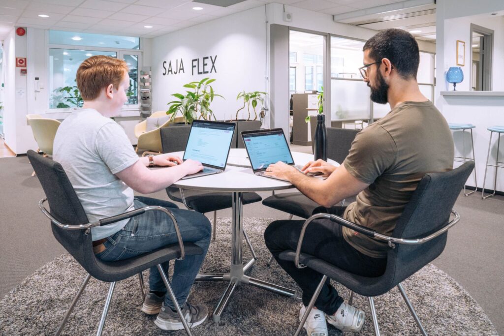 To personer i møte på digitalbyrå i Oslo, jobber med laptops.