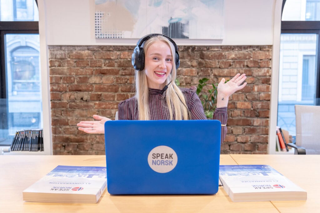 Kvinne med headset foran laptop som tilbyr språktjenester i Oslo.