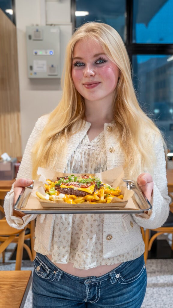 Kvinne med pizza i en moderne kafé i Oslo, digital markedsføring.