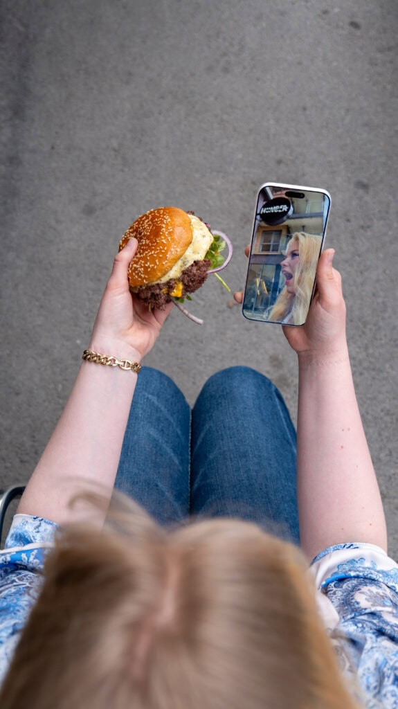 Person tar selfie med burger, digital markedsføring i Oslo.